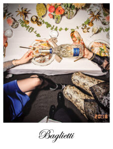 Donne al tavolo che si scambiano una bottiglia di vino nobel wines