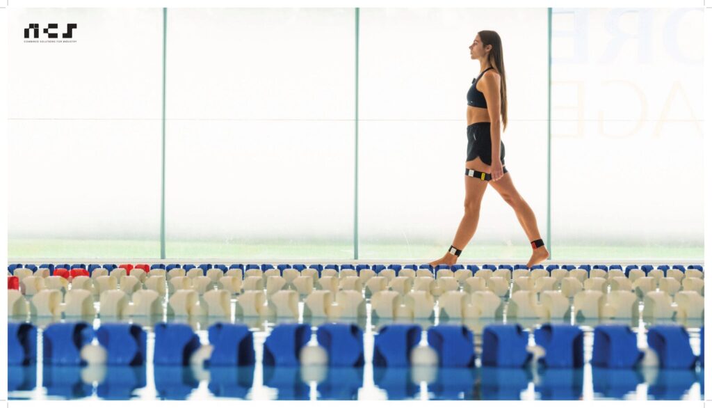 Atleta donna cammina davanti a transenne con dispositivo NCS Shoulder Pacemaker