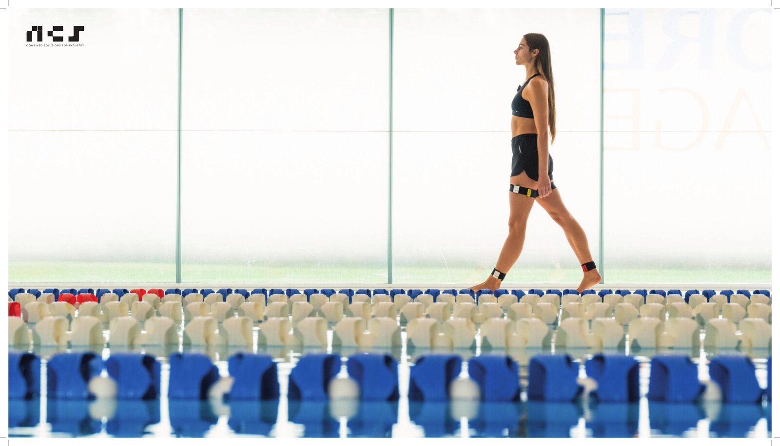 Atleta donna cammina davanti a transenne con dispositivo NCS Shoulder Pacemaker